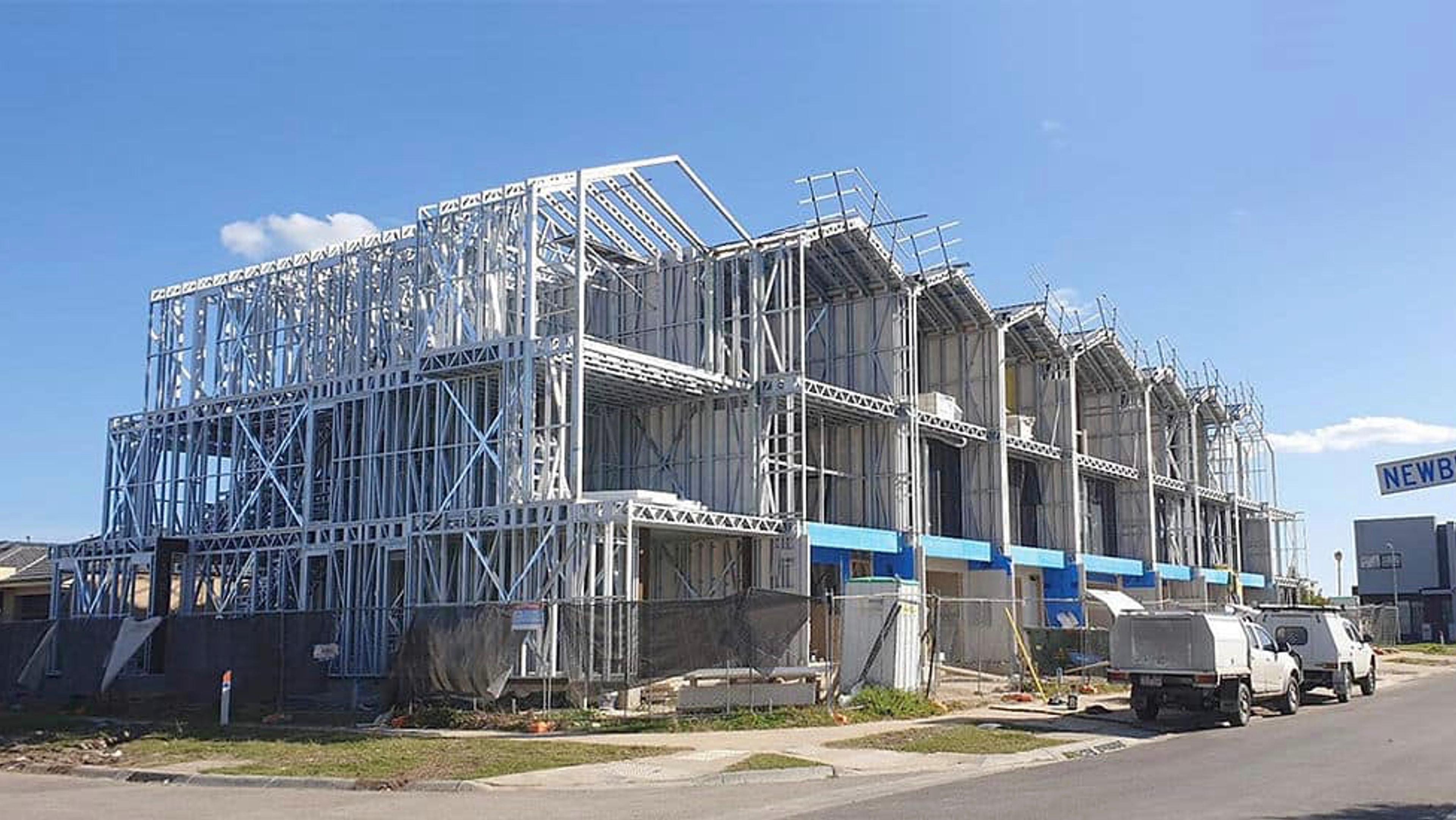 Light steel framing rising across a multi-home row housing project