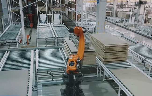 Industrial robotic arm moving panels through an automated manufacturing line