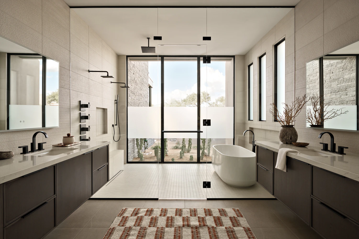 Bright bathroom with a glass shower, tub and double vanity.