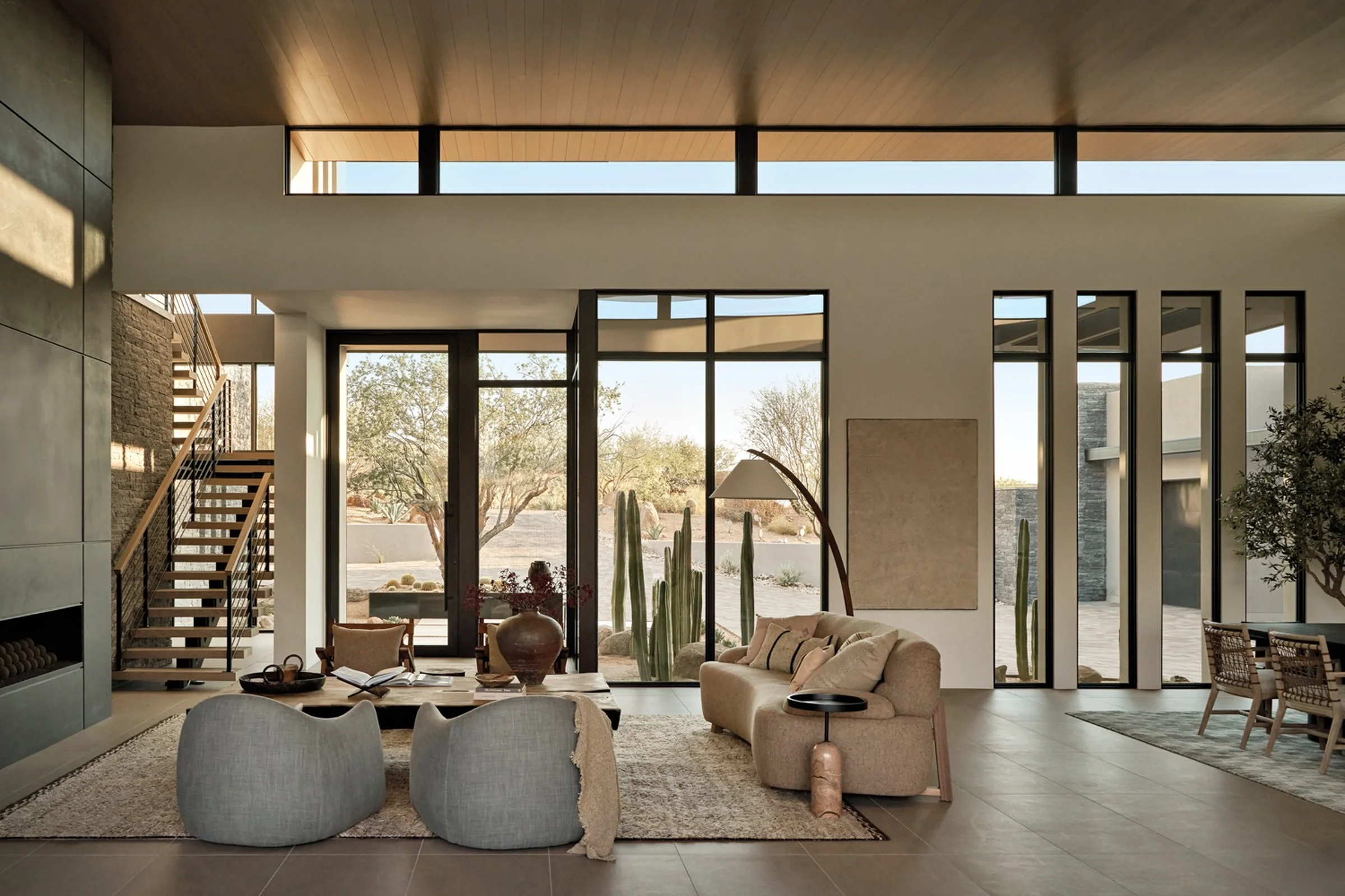 Contemporary interior with black-framed glazed doors, clerestory windows and an open-riser staircase.
